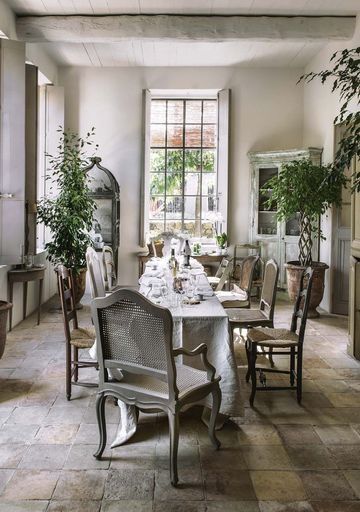 A light and airy dining room with lots of plants and natural wood furnishings